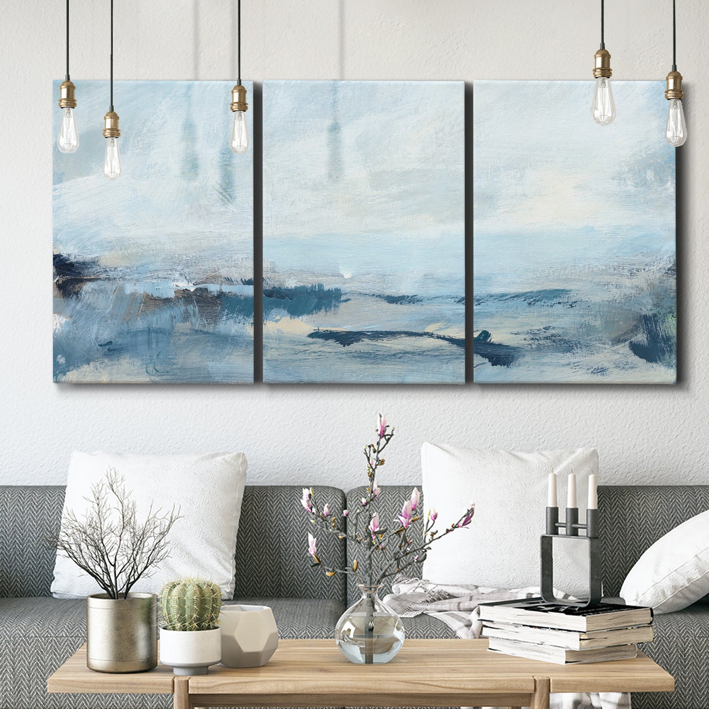 Three-panel canvas wall art featuring abstract sailboats on water, displayed in a modern living room above seating.