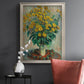 Impressionist floral painting of artichoke flowers by Claude Monet in an ornate champagne frame displayed in a dark-toned interior setting.