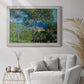 Impressionist Mediterranean coastal landscape by Claude Monet in an ornate weathered white frame displayed in a bright interior setting.