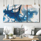 Three-panel canvas wall art featuring flowing blue abstract movement, displayed in a modern living room above seating.