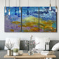 Three-panel canvas wall art featuring expressive abstract with layered color, displayed in a modern living room above seating.