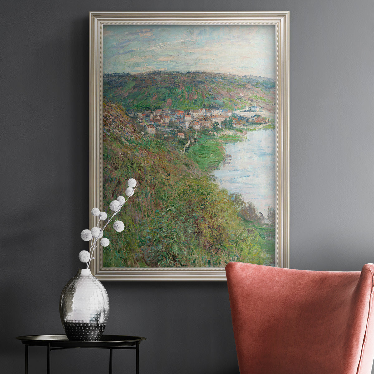 Impressionist landscape view of Vétheuil by Claude Monet in an ornate champagne frame displayed in a dark-toned interior setting.