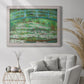 Impressionist garden scene with Japanese bridge and water lilies by Claude Monet in an ornate weathered white frame displayed in a bright interior setting.