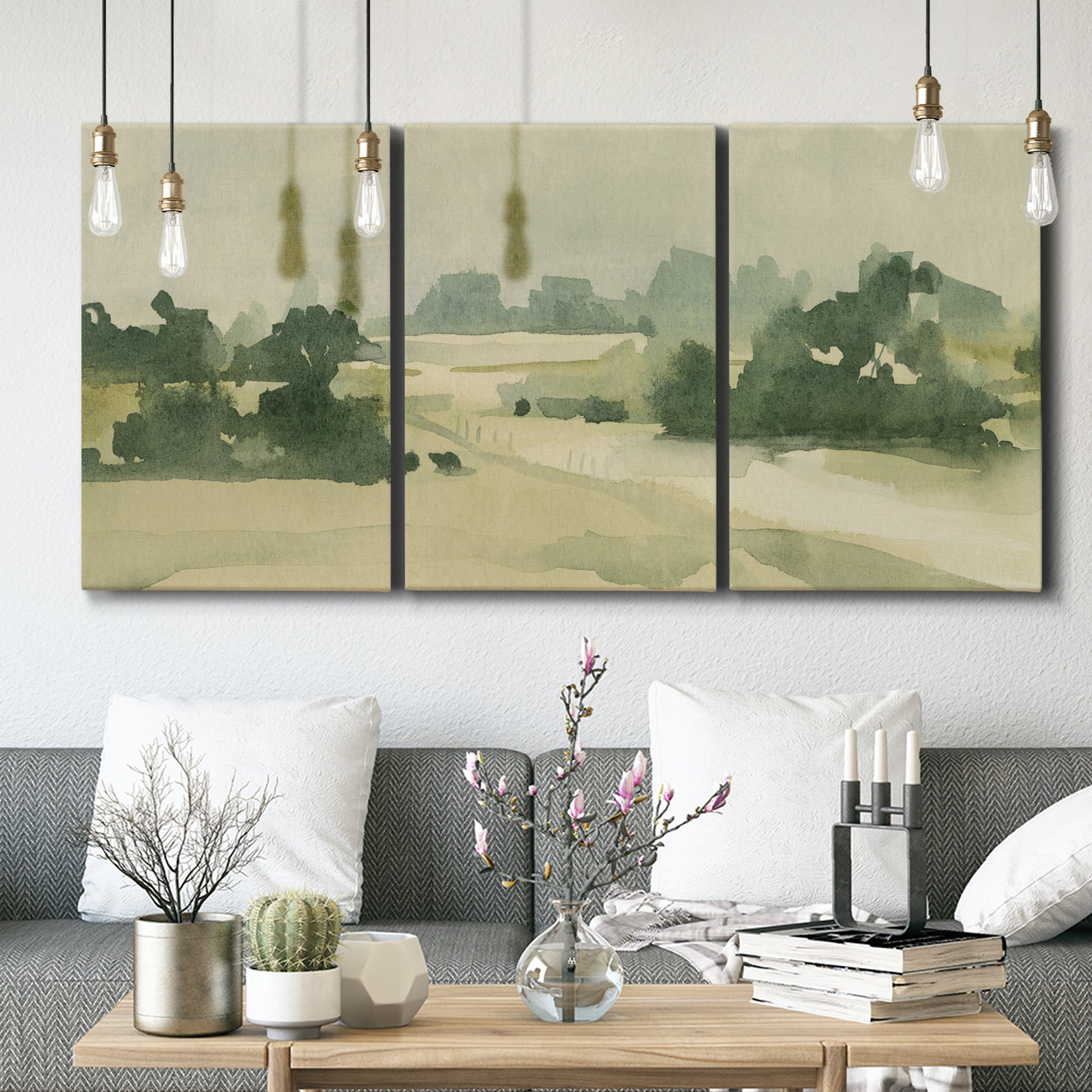 Three-panel canvas wall art featuring pasture landscape in soft watercolor, displayed in a modern living room above seating.