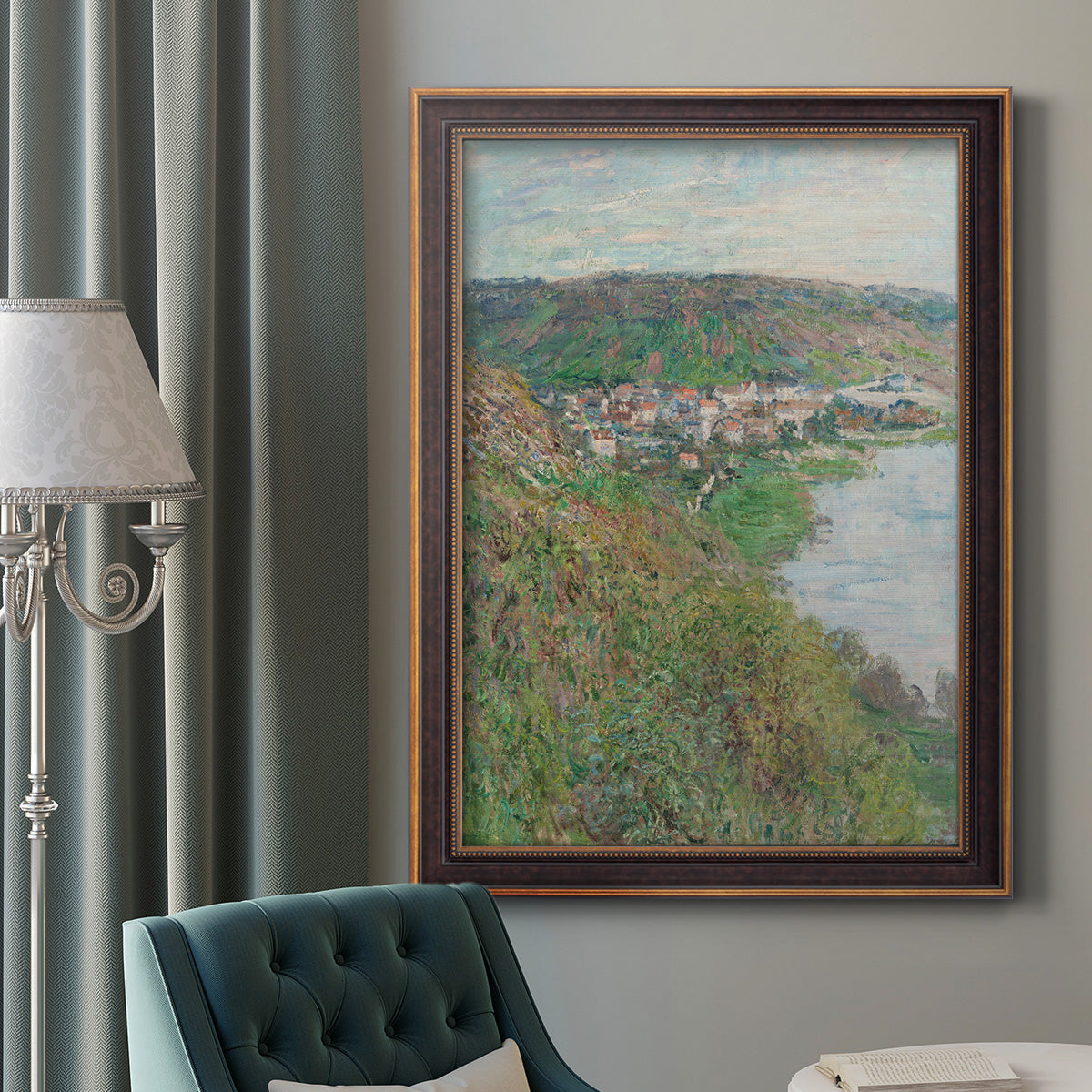 Impressionist landscape view of Vétheuil by Claude Monet in an ornate bronzed mahogany wood frame displayed in a dark-toned interior setting.