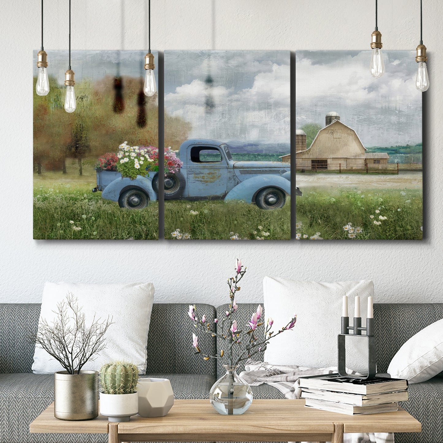 Three-panel canvas wall art featuring vintage blue truck with flower load, displayed in a modern living room above seating.