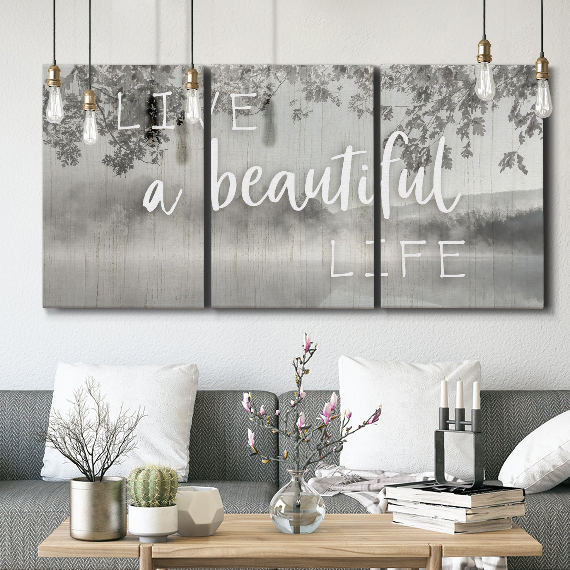 Three-panel canvas wall art featuring uplifting life themed typography, displayed in a modern living room above seating.