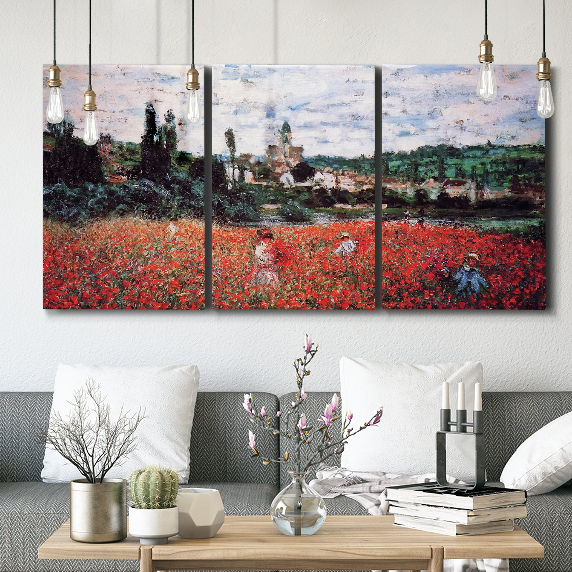 Three-panel canvas wall art featuring poppy field beside village landscape, displayed in a modern living room above seating.
