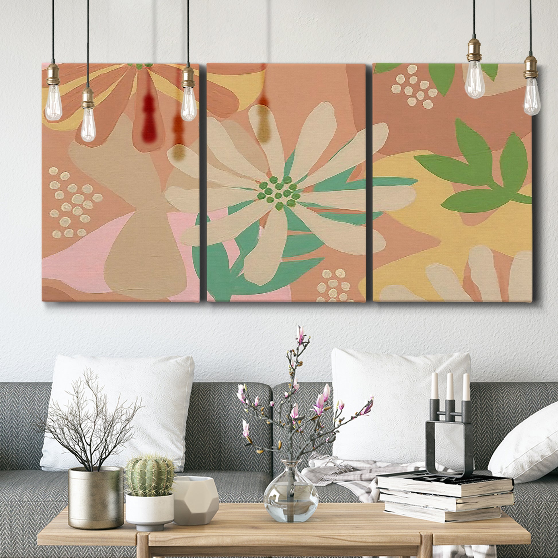 Three-panel canvas wall art featuring neutral toned botanical floral silhouettes, displayed in a modern living room above seating.