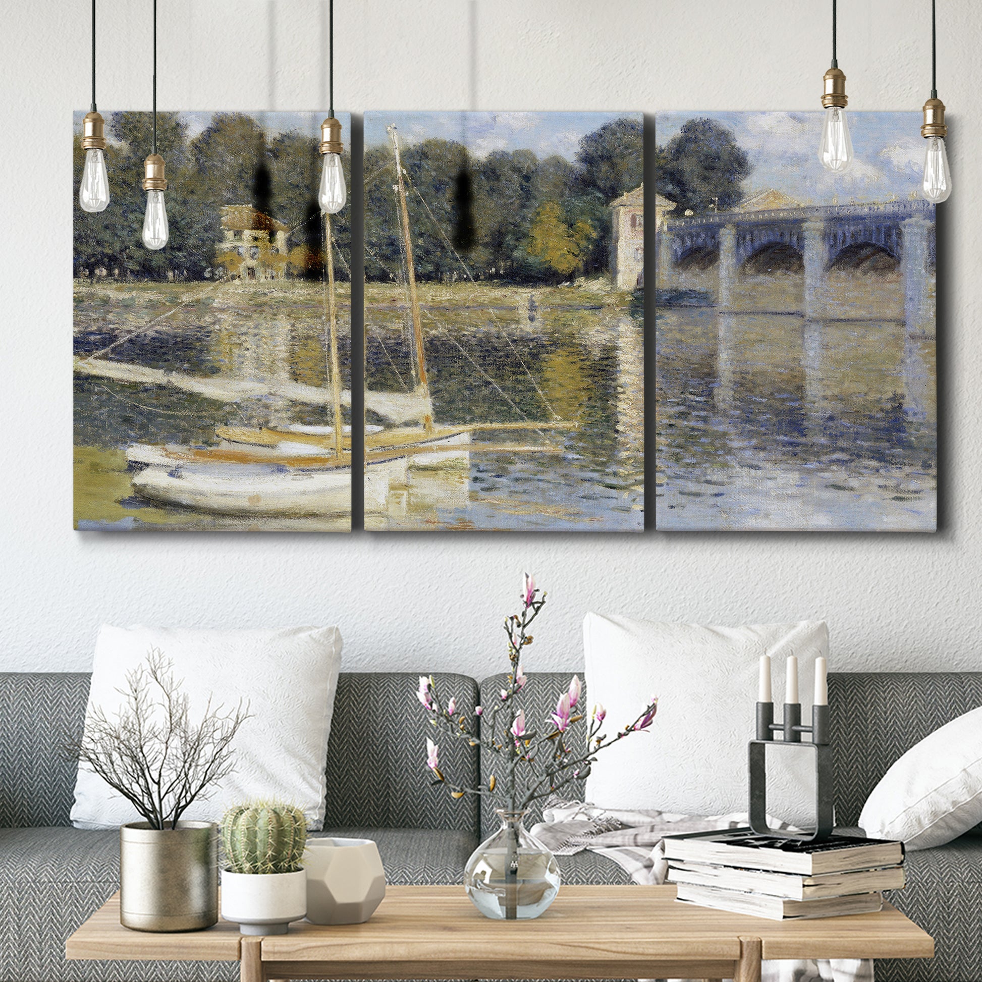 Three-panel canvas wall art featuring bridge crossing broad river, displayed in a modern living room above seating.