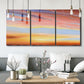 Three-panel canvas wall art featuring glowing sunset sky over landscape, displayed in a modern living room above seating.