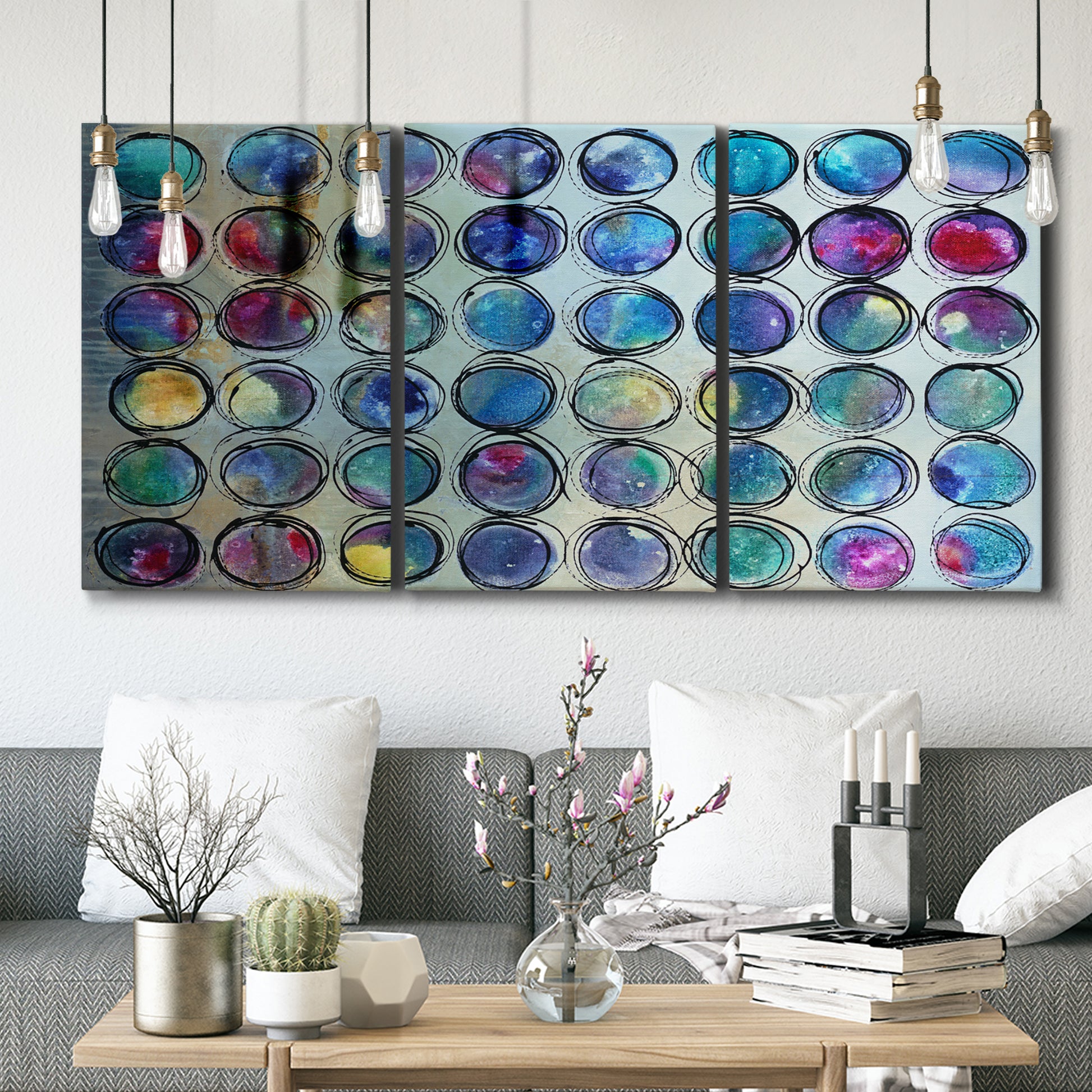 Three-panel canvas wall art featuring contrasting geometric abstract variations, displayed in a modern living room above seating.