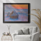 Impressionist haystack scene at sunset by Claude Monet in an ornate black frame with gilded inner detail displayed in a bright interior setting.