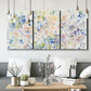 Three-panel canvas wall art featuring flowing abstract watercolor, displayed in a modern living room above seating.