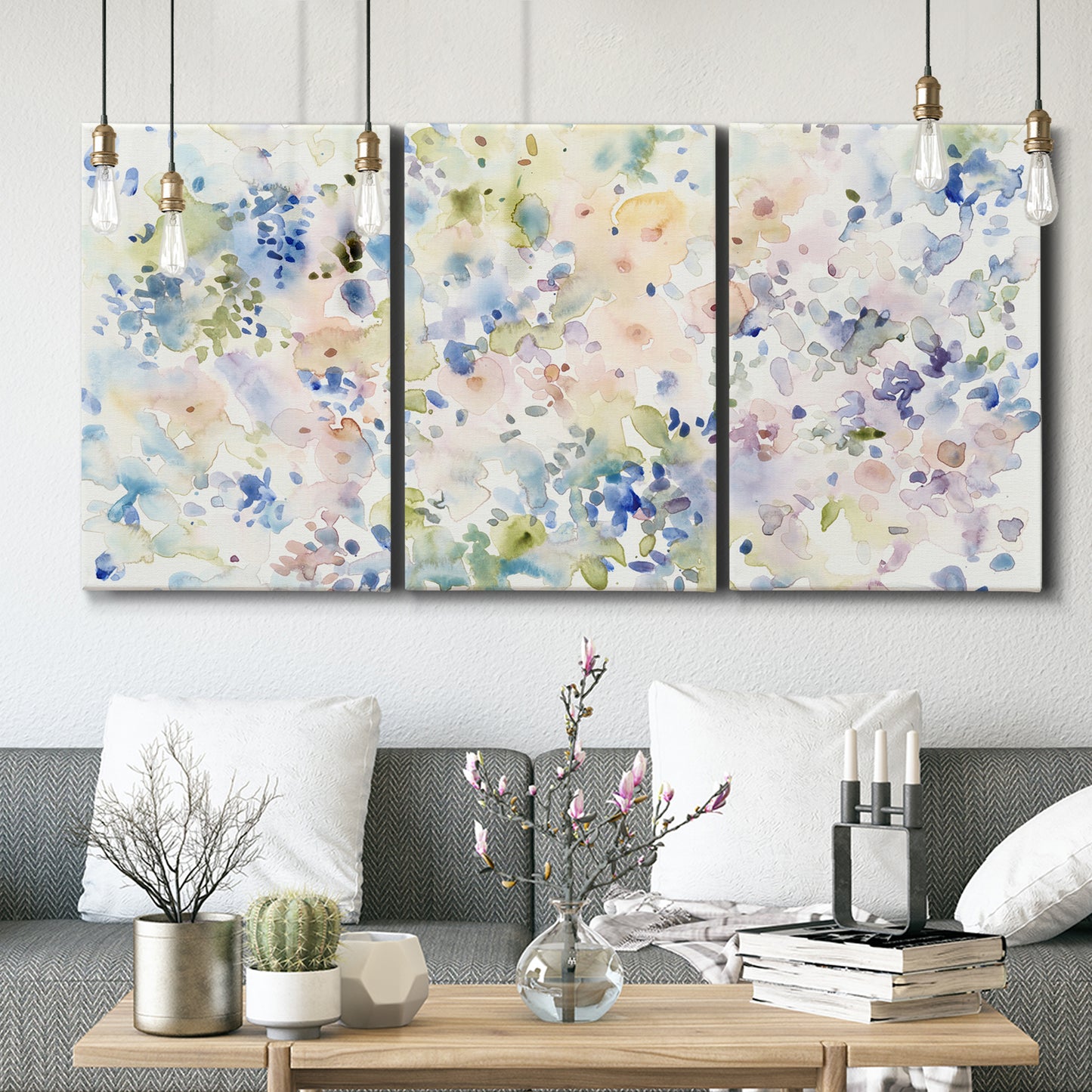 Three-panel canvas wall art featuring flowing abstract watercolor, displayed in a modern living room above seating.