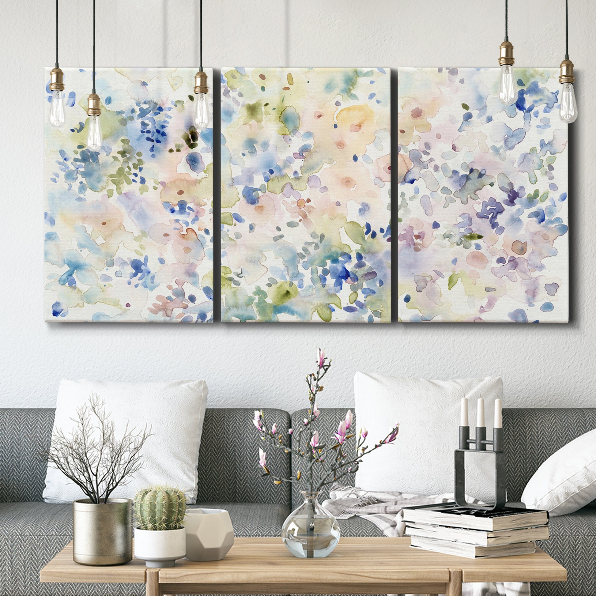 Three-panel canvas wall art featuring flowing abstract watercolor, displayed in a modern living room above seating.