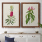 Set of two maple barnwood framed canvas prints depicting a coordinated art pair of pink flowering plant specimens rendered as vintage botanical plate illustrations above a dining room sideboard.
