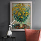 Impressionist floral painting of artichoke flowers by Claude Monet in an ornate weathered white frame displayed in a dark-toned interior setting.