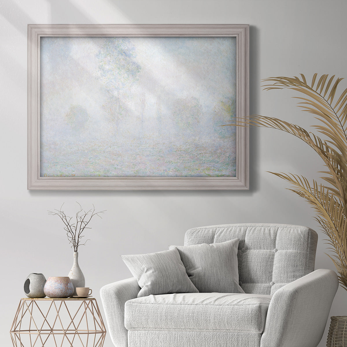 Impressionist atmospheric landscape in morning haze by Claude Monet in an ornate weathered white frame displayed in a bright interior setting.
