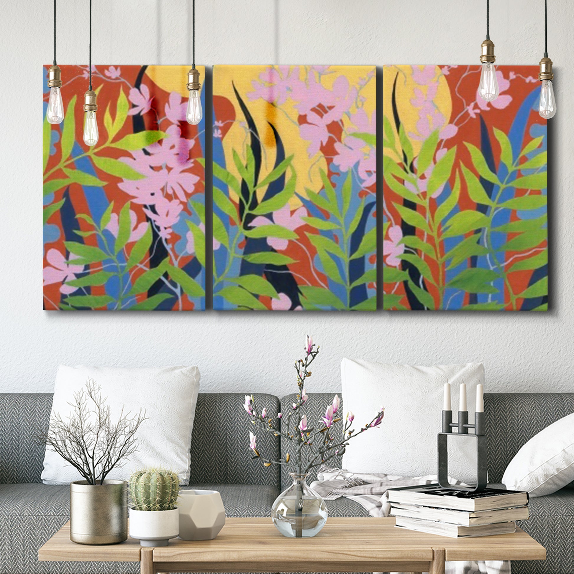 Three-panel canvas wall art featuring bold colorful floral abstraction, displayed in a modern living room above seating.