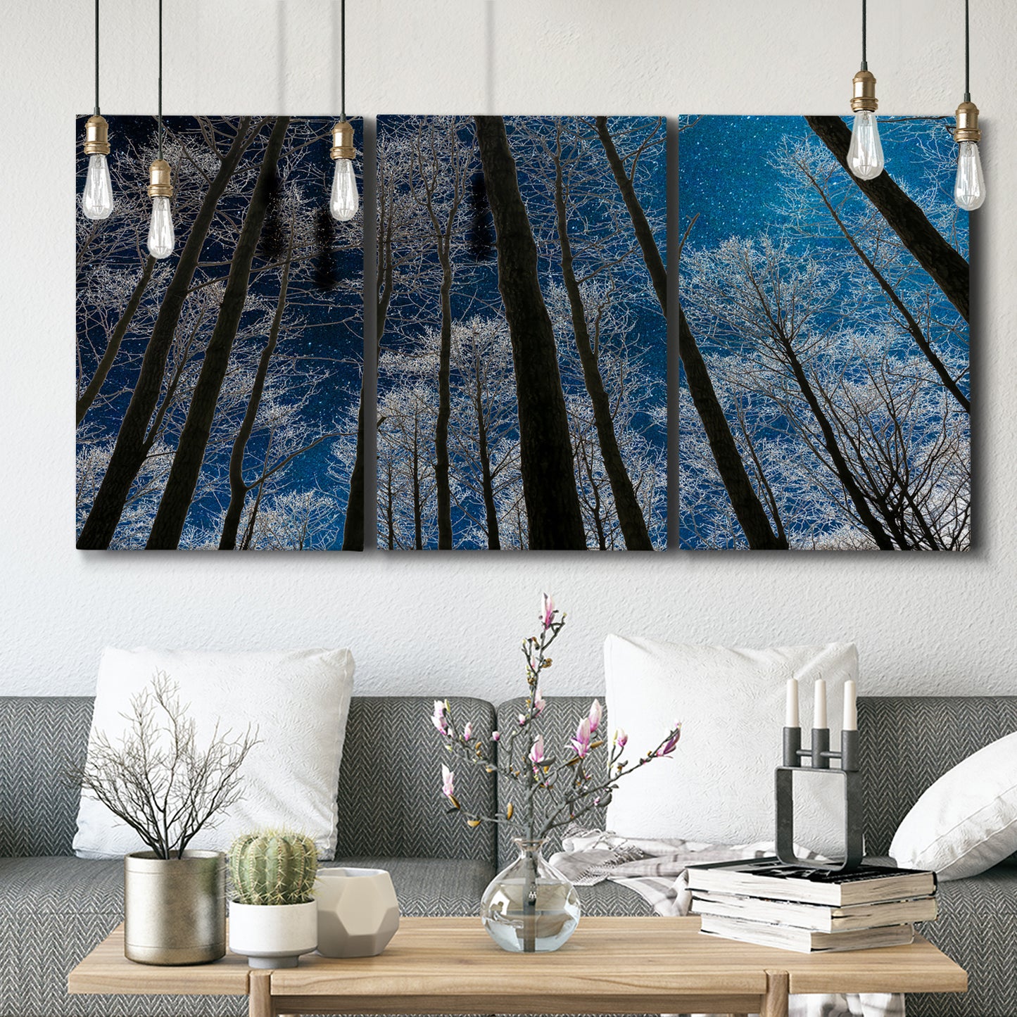 Three-panel canvas wall art featuring night landscape silhouette photography, displayed in a modern living room above seating.