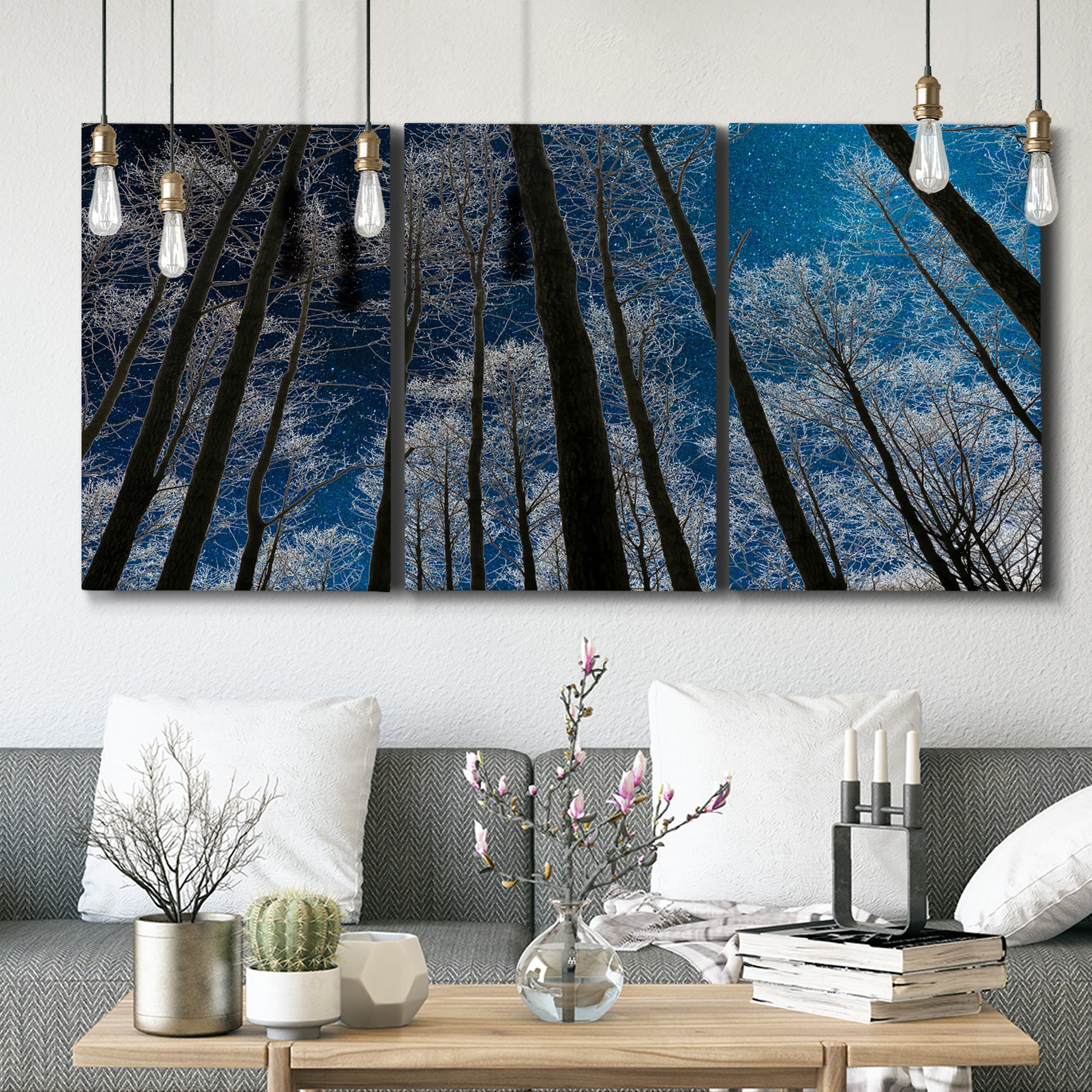 Three-panel canvas wall art featuring night landscape silhouette photography, displayed in a modern living room above seating.