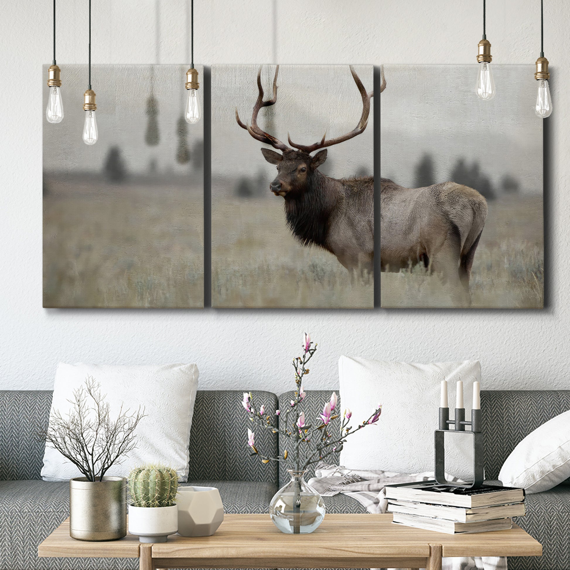Three-panel canvas wall art featuring elk standing in open grassland, displayed in a modern living room above seating.