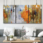 Three-panel canvas wall art featuring abstract warm sunset tones, displayed in a modern living room above seating.