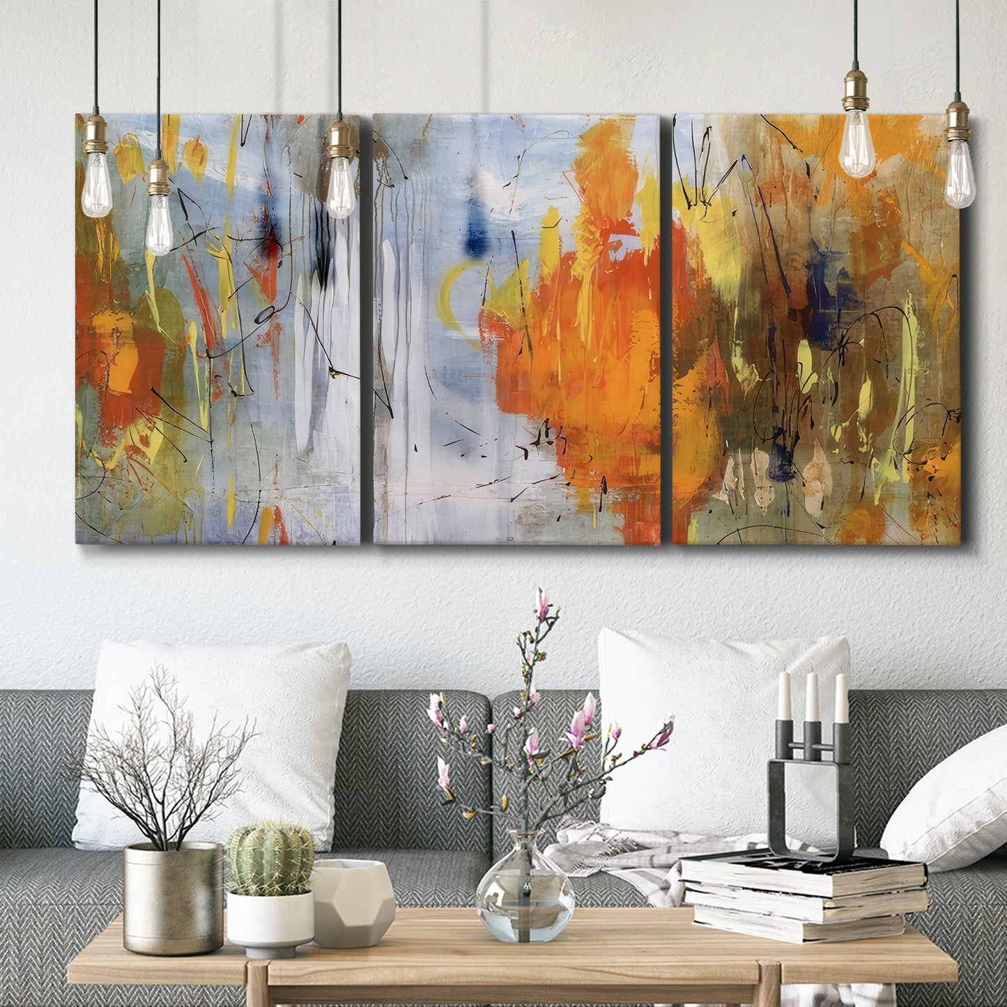 Three-panel canvas wall art featuring abstract warm sunset tones, displayed in a modern living room above seating.