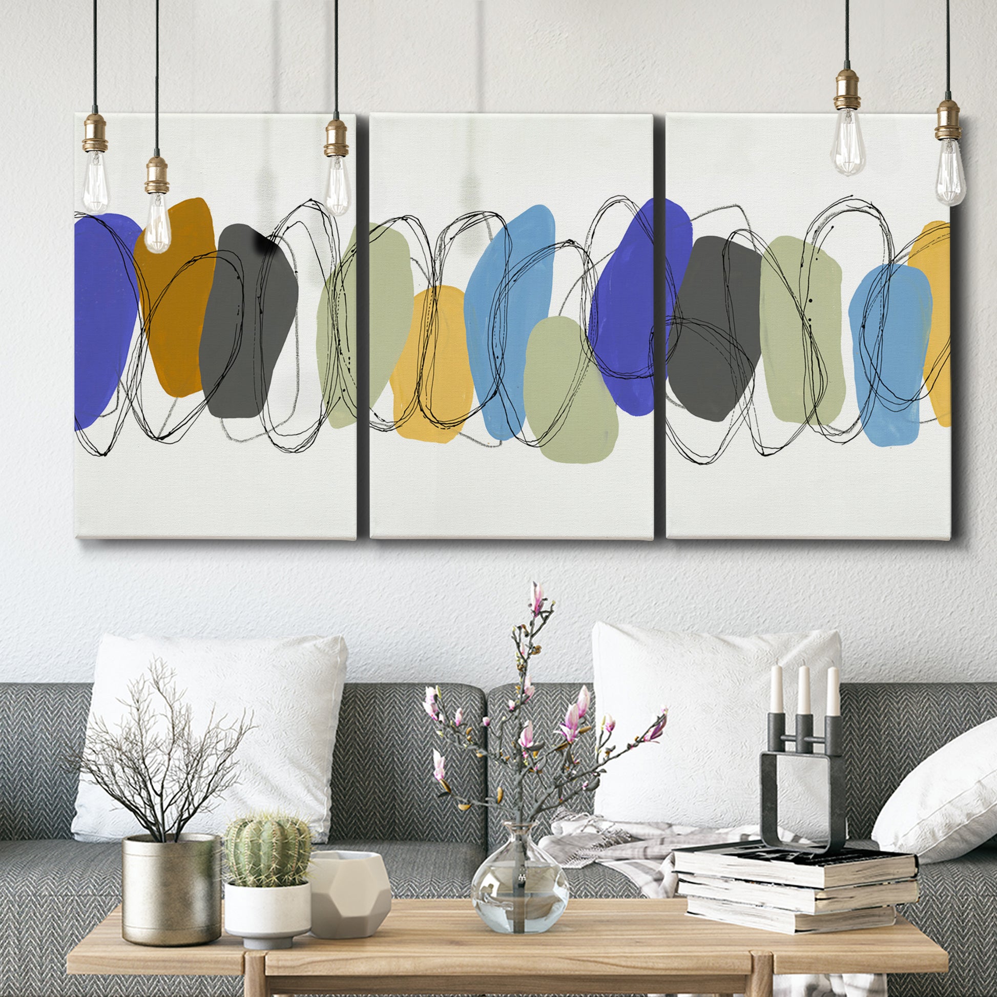 Three-panel canvas wall art featuring minimalist geometric abstract spacing, displayed in a modern living room above seating.