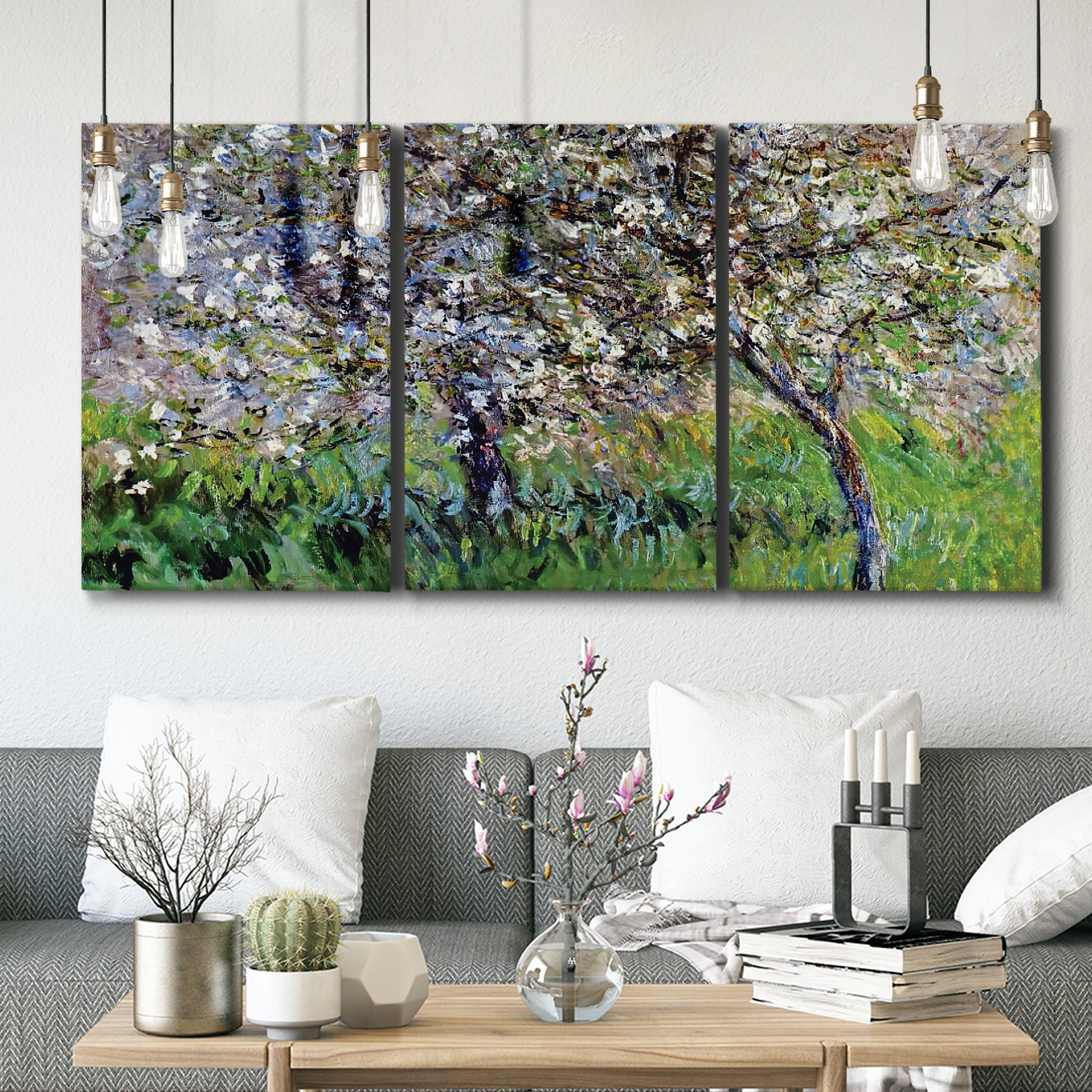 Three-panel canvas wall art featuring apple trees blooming beside water, displayed in a modern living room above seating.