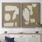 Set of two gray barnwood framed canvas prints depicting a coordinated art pair of irregular white cutout-like shapes on taupe grounds rendered as bold minimalist shape abstracts above a dining room sideboard.