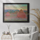 Impressionist haystack series landscape by Claude Monet in an ornate black frame with gilded inner detail displayed in a bright interior setting.