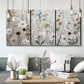 Three-panel canvas wall art featuring misty wildflower meadow landscape, displayed in a modern living room above seating.