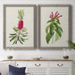 Set of two gray barnwood framed canvas prints depicting a coordinated art pair of pink flowering plant specimens rendered as vintage botanical plate illustrations above a dining room sideboard.