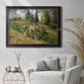 Impressionist countryside harvest scene by Camille Pissarro in an ornate black frame with gilded inner detail displayed in a bright interior setting.