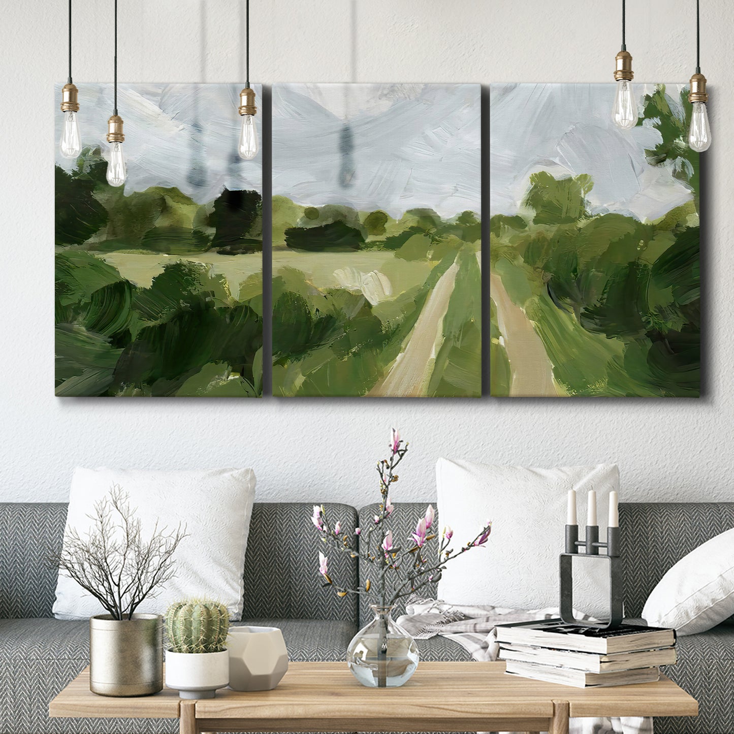 Three-panel canvas wall art featuring meadow trail through open grassland, displayed in a modern living room above seating.
