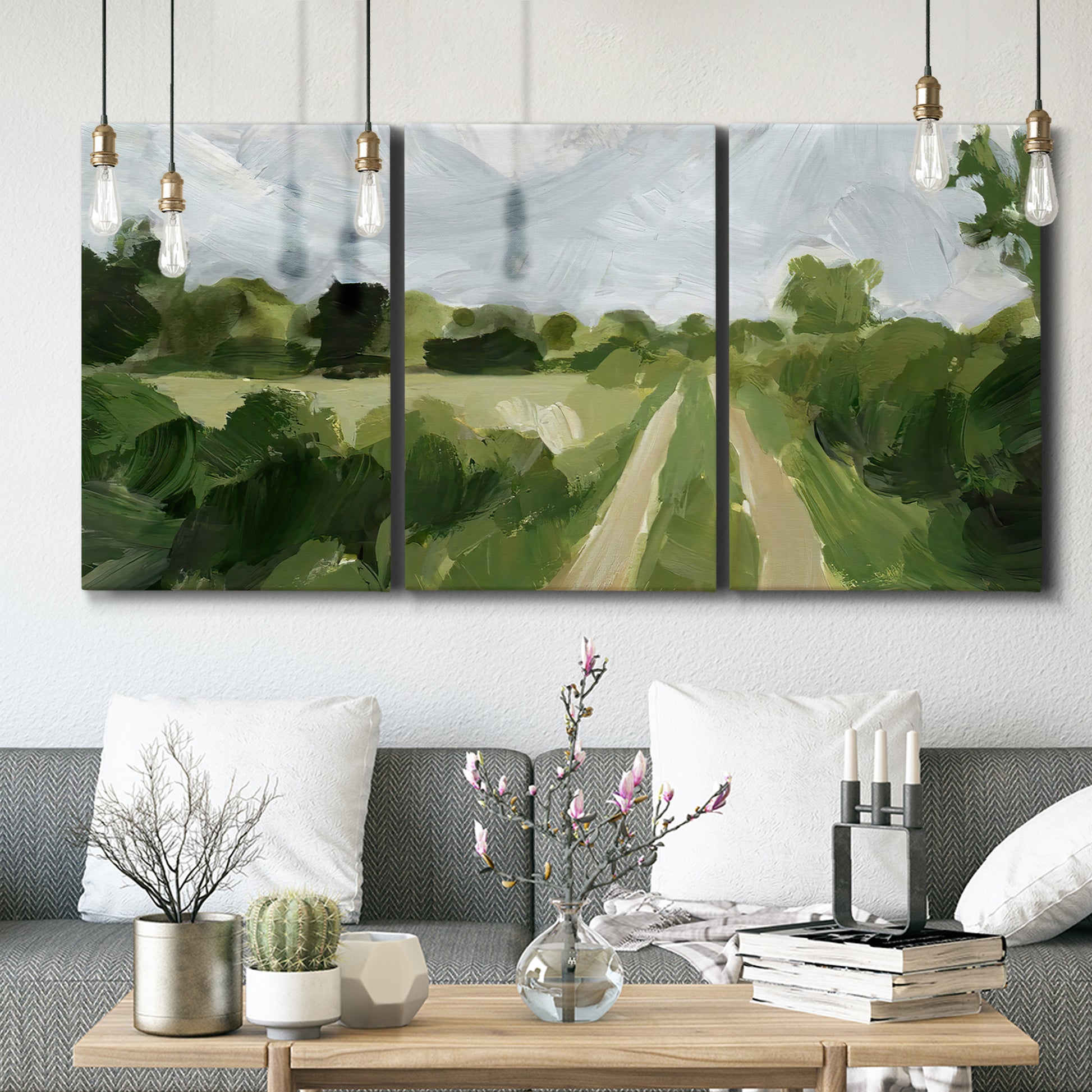 Three-panel canvas wall art featuring meadow trail through open grassland, displayed in a modern living room above seating.