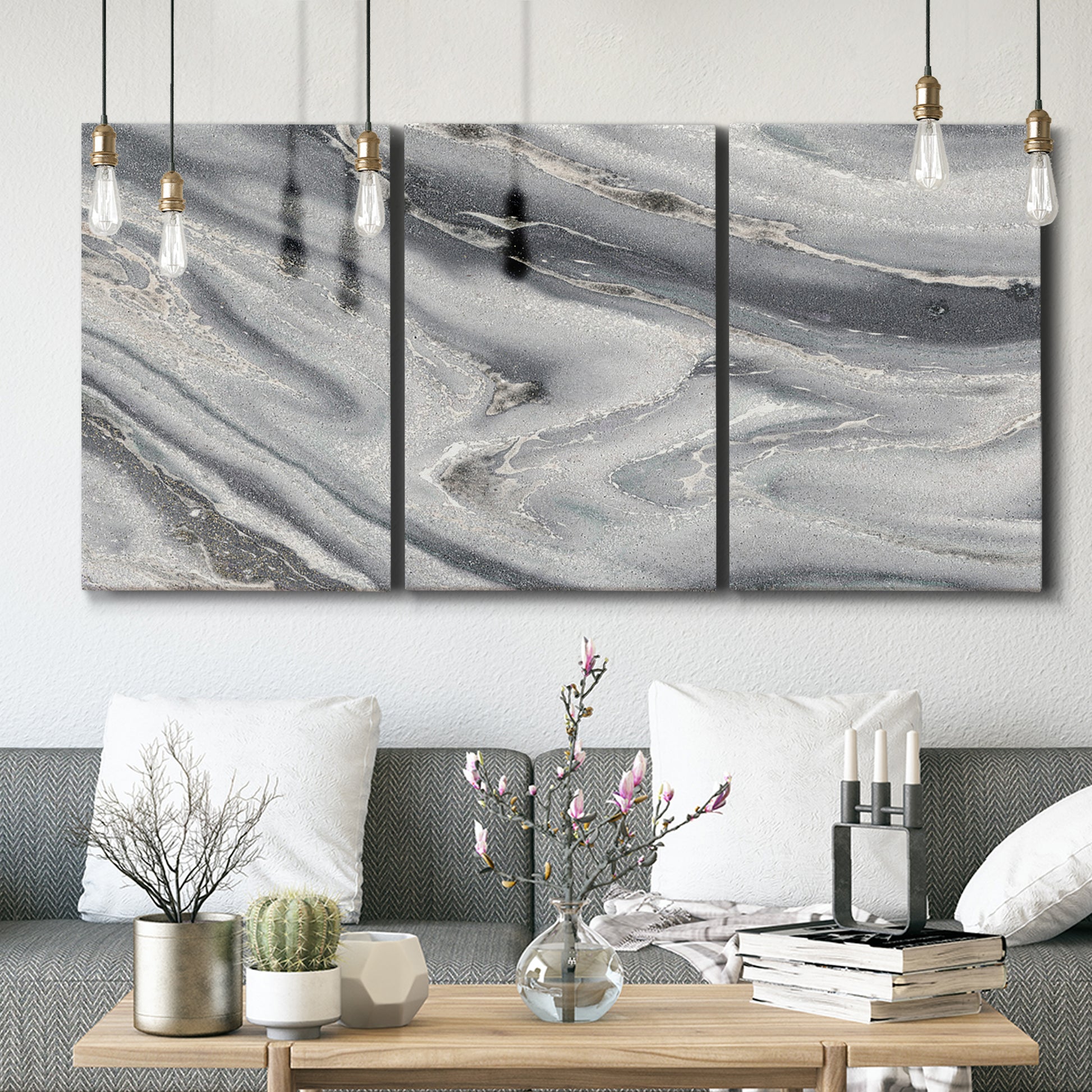 Three-panel canvas wall art featuring minimal monochrome abstract forms, displayed in a modern living room above seating.
