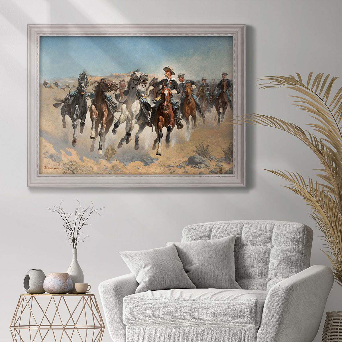 Impressionist western action scene by Frederic Remington in an ornate weathered white frame displayed in a bright interior setting.