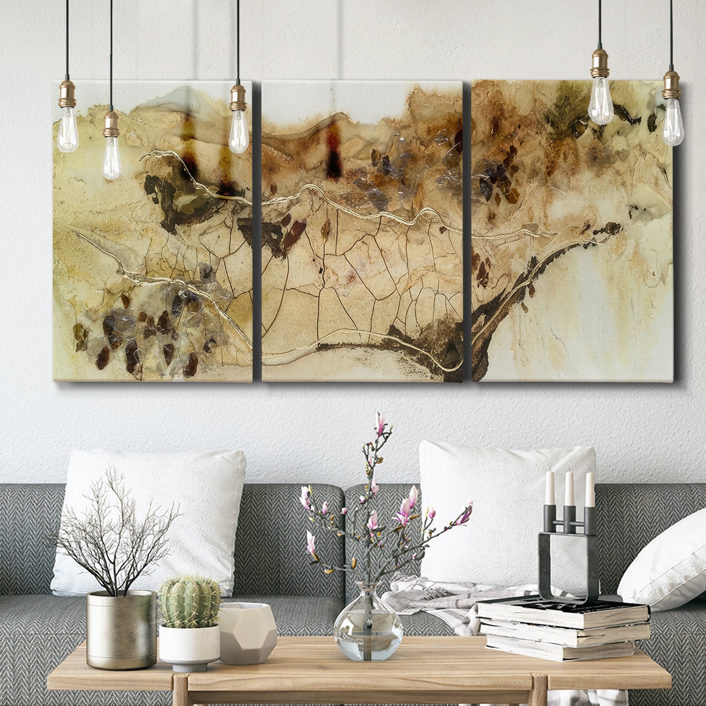 Three-panel canvas wall art featuring muted abstract with metallic gold accents, displayed in a modern living room above seating.