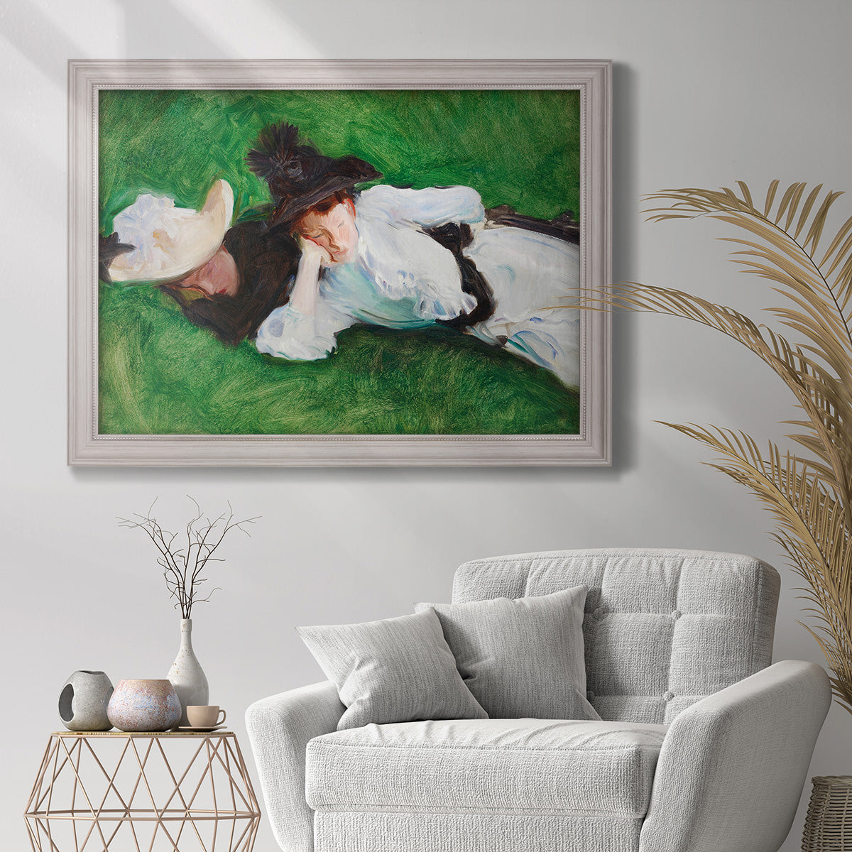 Impressionist outdoor portrait of two girls by John Singer Sargent in an ornate weathered white frame displayed in a bright interior setting.
