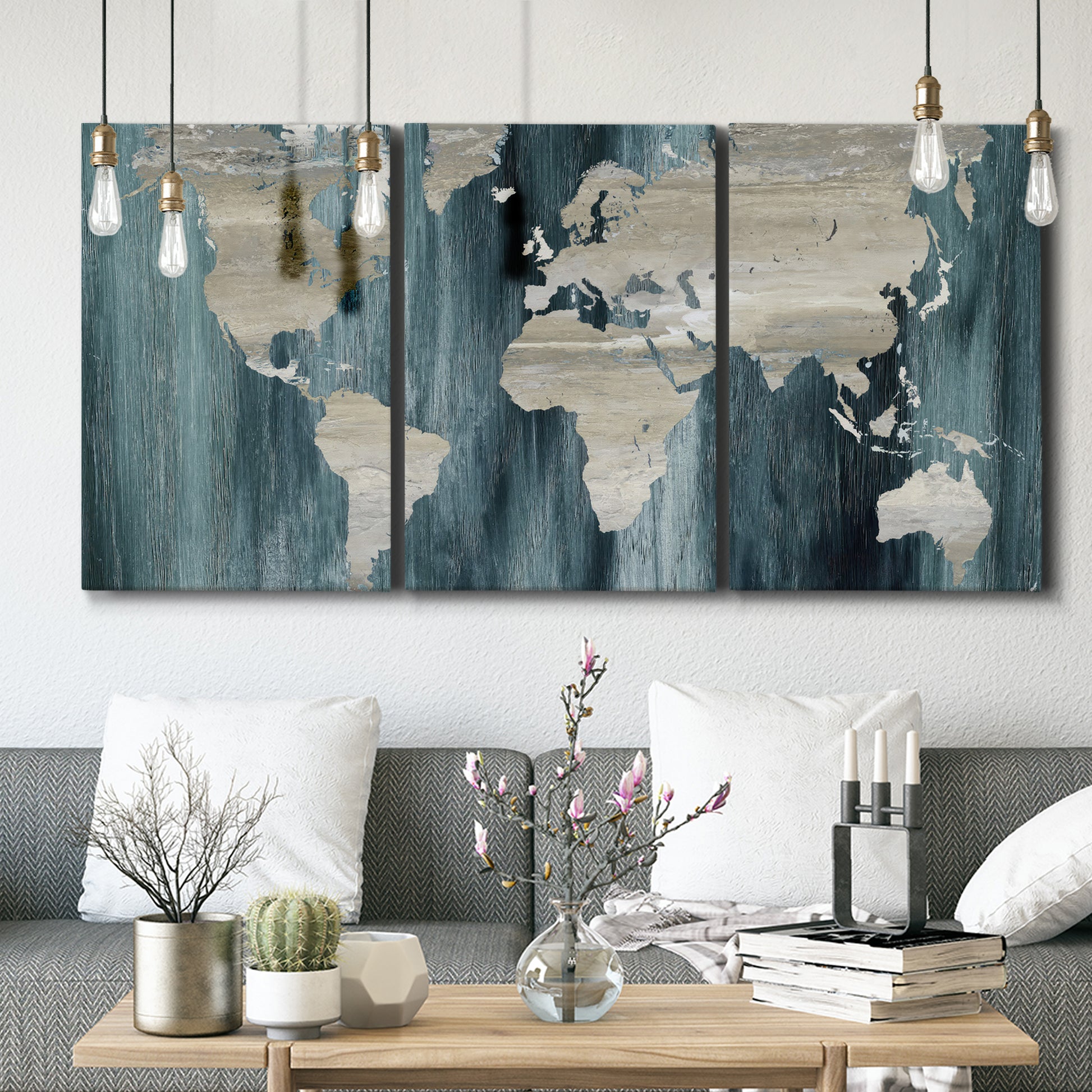 Three-panel canvas wall art featuring golden coastal sunset with cliffs, displayed in a modern living room above seating.