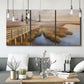 Three-panel canvas wall art featuring coastal path along dunes, displayed in a modern living room above seating.