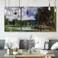 Three-panel canvas wall art featuring riverbank landscape near village, displayed in a modern living room above seating.