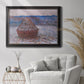 Impressionist single haystack landscape by Claude Monet in an ornate black frame with gilded inner detail displayed in a bright interior setting.