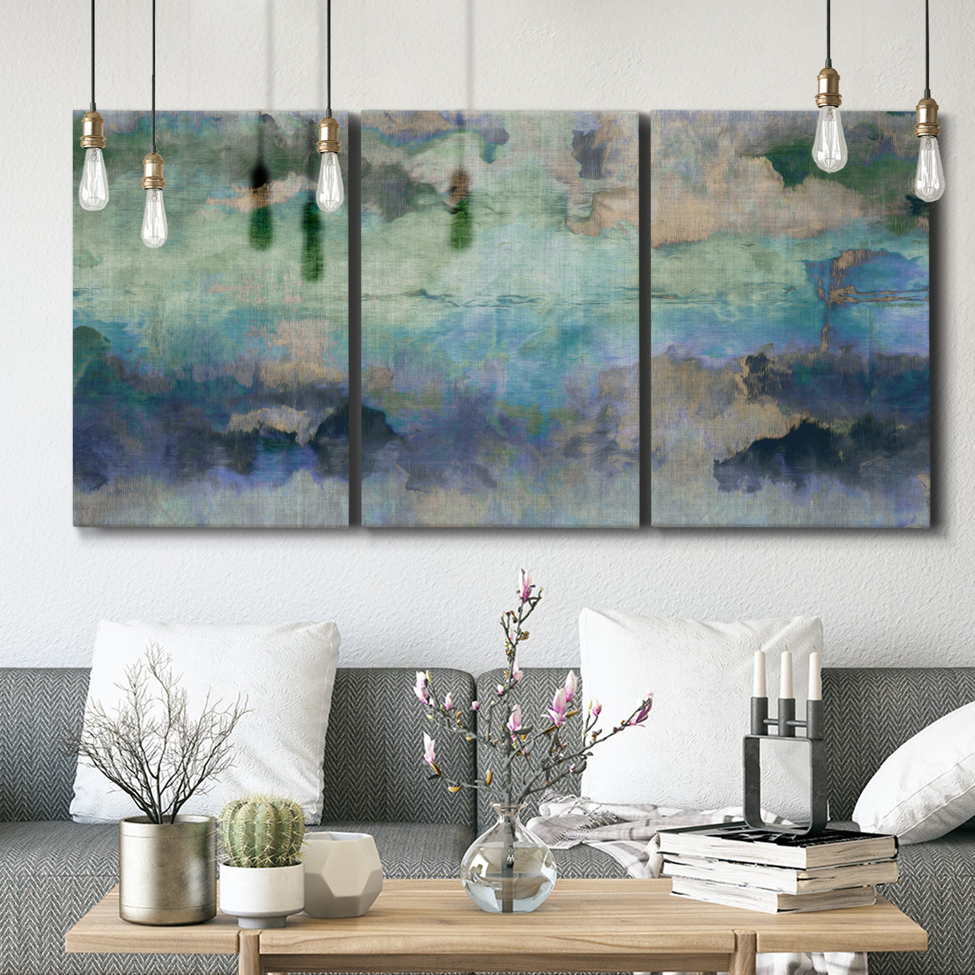 Three-panel canvas wall art featuring cool dreamy abstraction, displayed in a modern living room above seating.