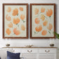 Set of two maple barnwood framed canvas prints depicting a coordinated art pair of loose peach-orange tulip-like blossoms rendered as airy watercolor floral paintings above a dining room sideboard.