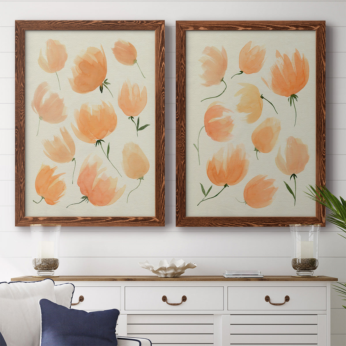 Set of two maple barnwood framed canvas prints depicting a coordinated art pair of loose peach-orange tulip-like blossoms rendered as airy watercolor floral paintings above a dining room sideboard.