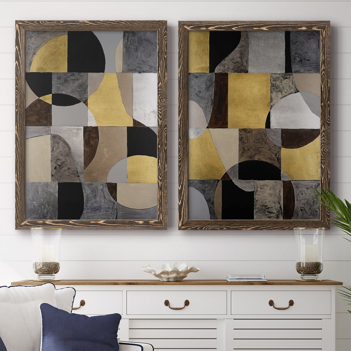 Set of two walnut barnwood framed canvas prints depicting a coordinated art pair of interlocking black gray cream and gold geometric sections rendered as structured modern abstracts above a dining room sideboard.